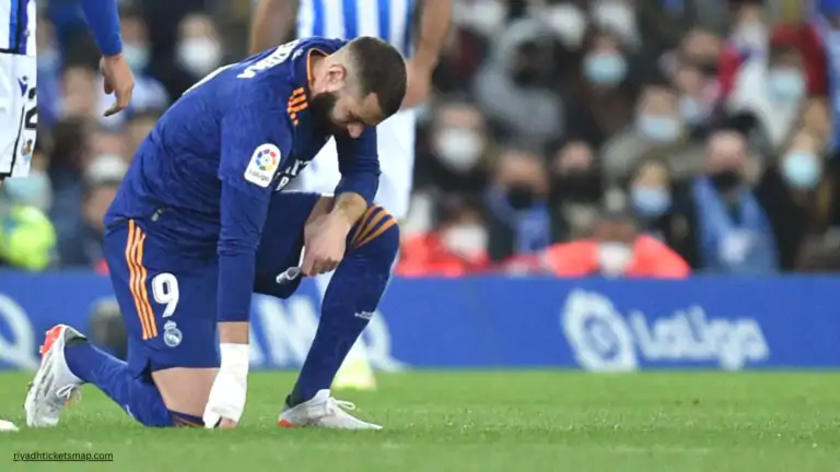 Karim Benzema kneels on the pitch holding his leg during a La Liga match, highlighting the injury setback that could impact the Saudi Pro League title race involving Cristiano Ronaldo and Al Nassr.
